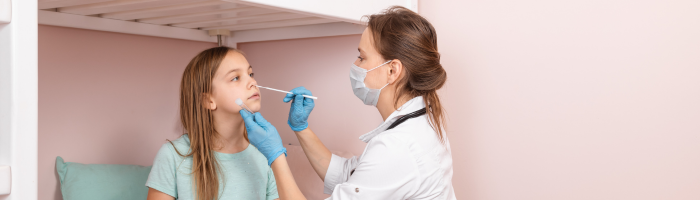 Medical professional taking nasopharynx sample from young girl